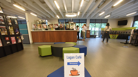Image of the Logan cafe from a distance with sign pointing to the entrance